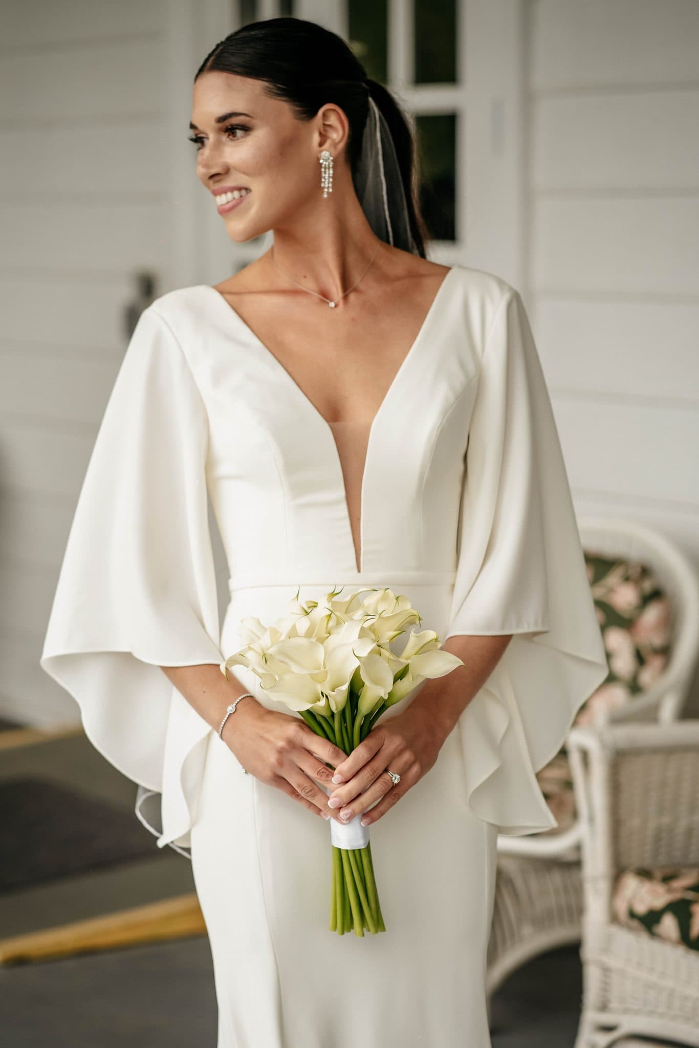 Bride holding a calla lily bouquet on a porch