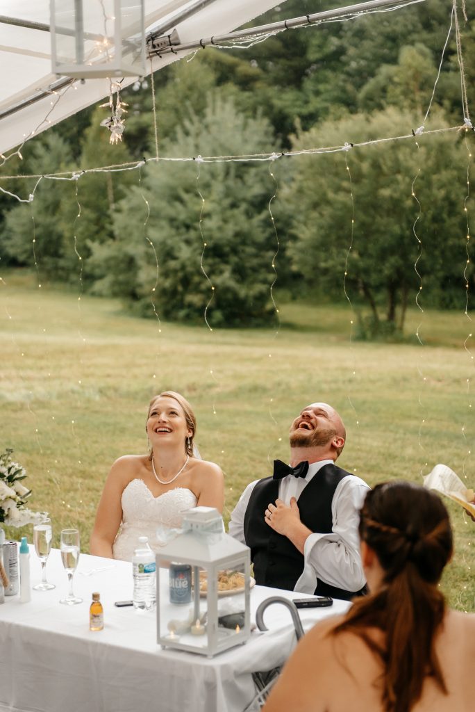 A groom laughs with his bride at their outdoor reception venue knowing how many witnesses to get married in new york