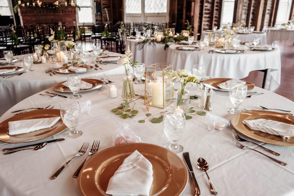 Nicely decorated dinner tables at a reception in one of the upstate new york barn wedding venues